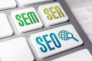Teclas de teclado con SEM verde SEA amarillo y SEO azul con globo y lupa