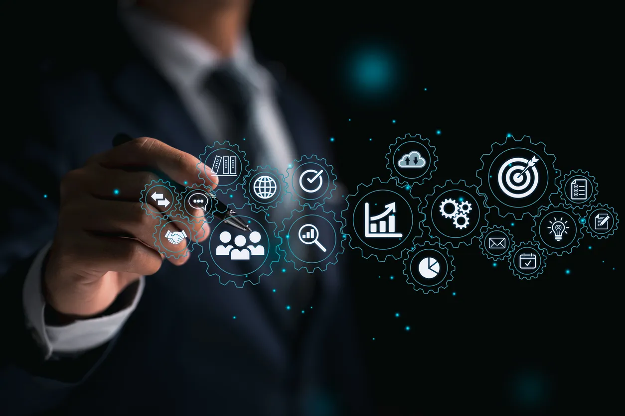 Un hombre de traje interactúa con iconos digitales de negocios y tecnología en una interfaz virtual.