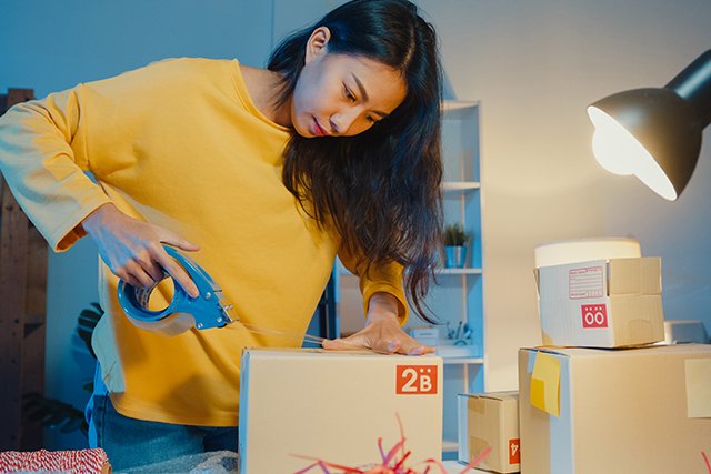 Mujer empresaria preparando un paquete para enviarlo