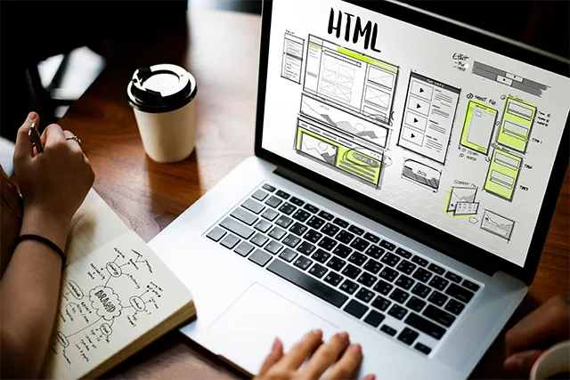 Diseñador trabajando en el rediseño de un sitio web, mostrando un diseño moderno y una interfaz de usuario optimizada.