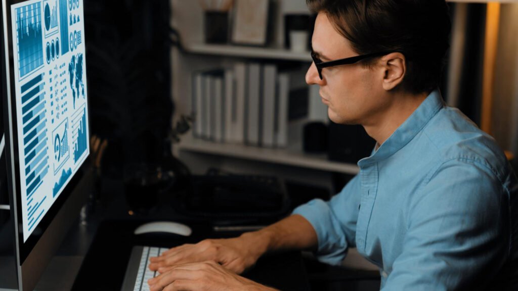 Un profesional de marketing analizando gráficos de datos y métricas de rendimiento en un monitor de computadora para optimizar estrategias de GEO y AEO.